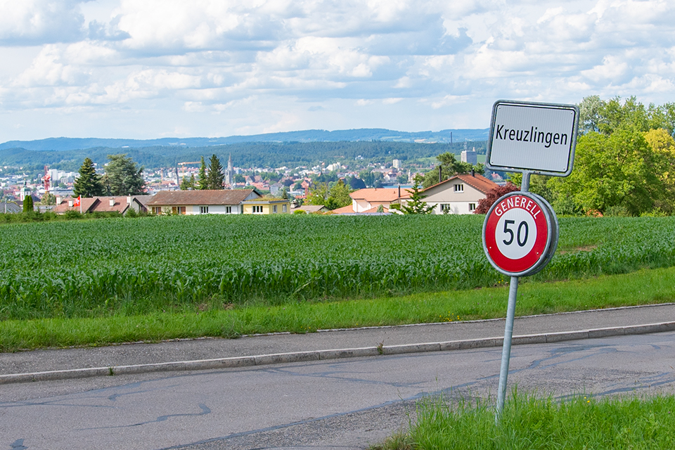 Das Bild zeigt ein Dorfeingangsschild von Kreuzlingen und darunter ein Verkehrsschild mit Höchstgeschwindigkeit 50.