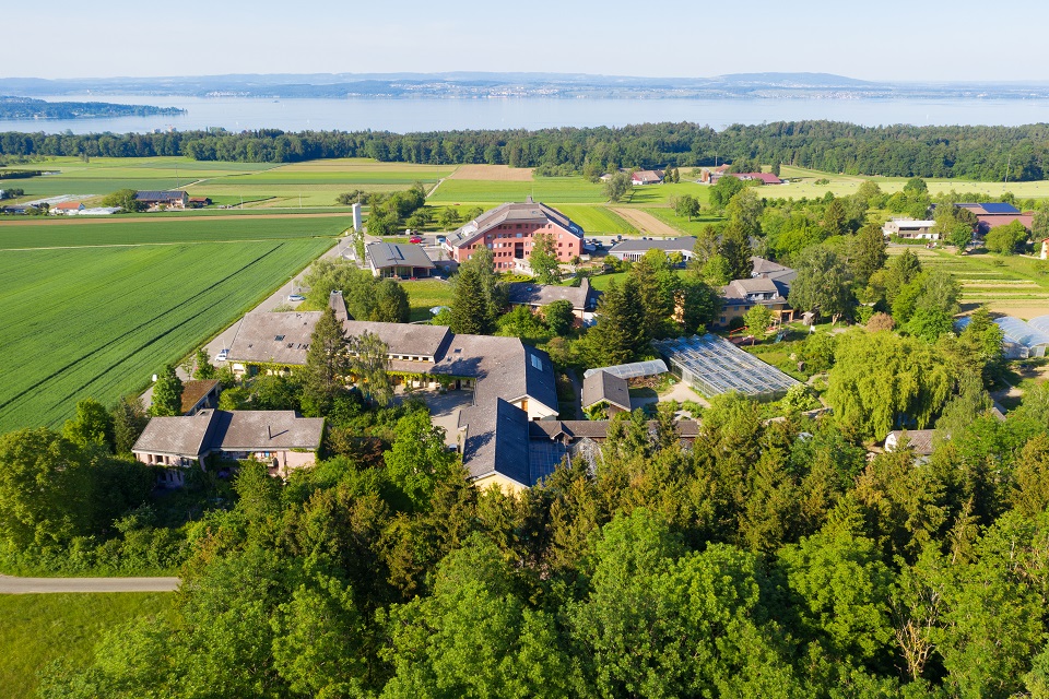 Das Bild zeigt eine Luftaufnahme des Ekkharthof Geländes in Lengwil. Im Hintergrund befindet sich der Bodensee.