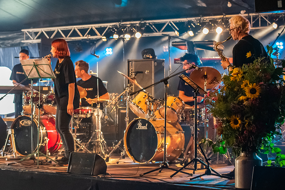 Das Bild zeigt eine Musikband bei ihrem Auftritt in einem Festzelt.