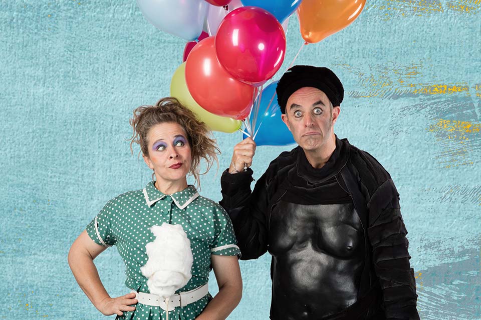 Das Bild zeigt einen Mann und eine Frau mit Ballonen in den Händen.