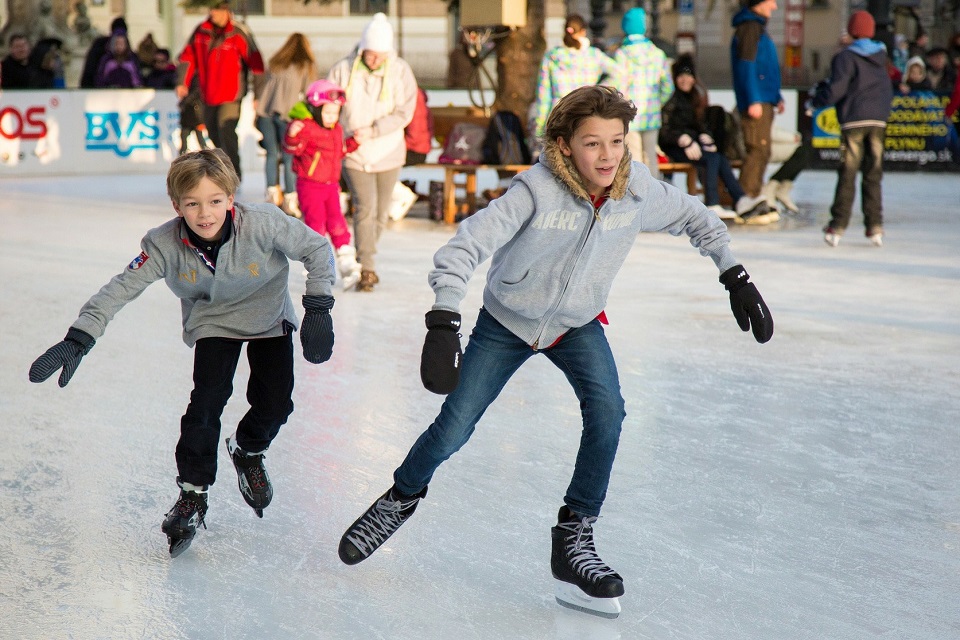 Das Bild zeigt zwei Jungen beim Eislaufen.