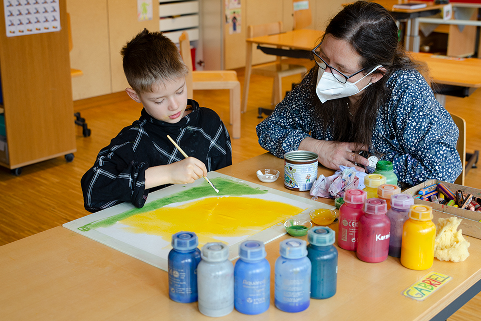 Das Bild zeigt eine Kind beim Malen.