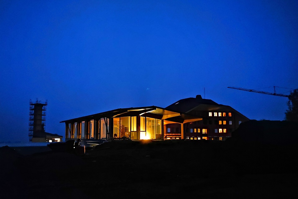 Das Bild zeigt ein hell beleuchtetes Gebäude in der Nacht.