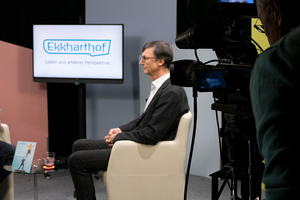 Das Bild zeigt Jürg Bregenzer bei einem Interview im Fernsehstudio vor der Kamera.