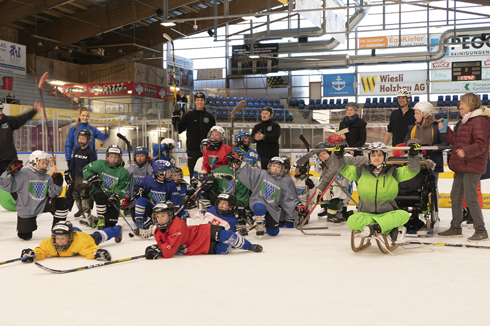 Das Bild zeigt eine grosse Gruppe junger Eishockeyspieler beim Posieren für ein Gruppenfoto.