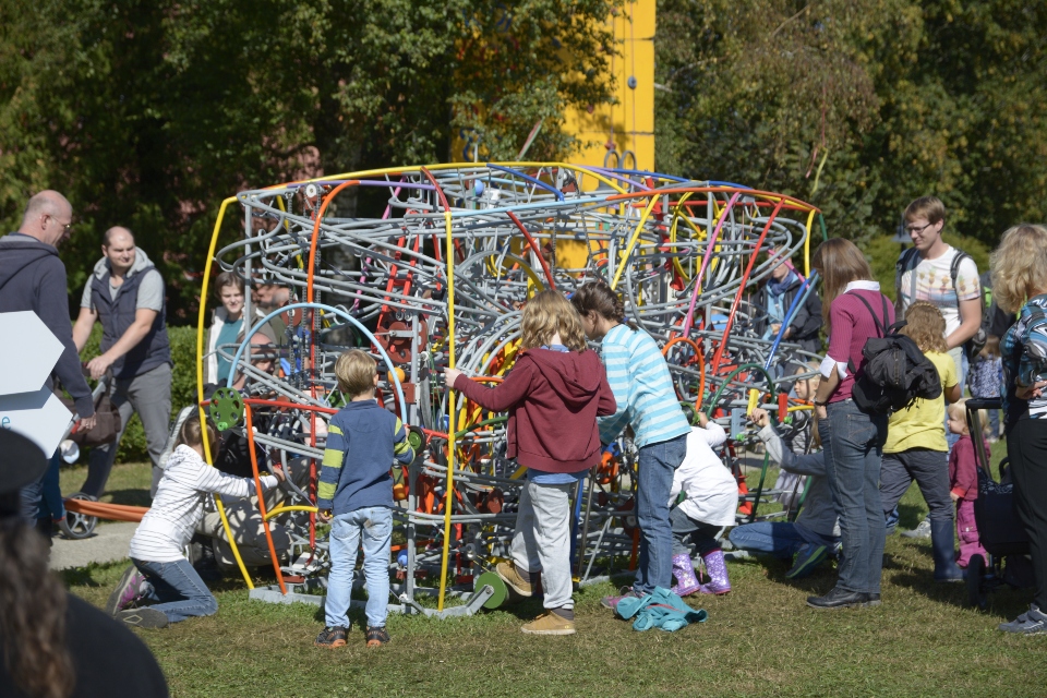 Das Bild zeigt viele Kinder mit einer grossen Kugelbahn spielen.