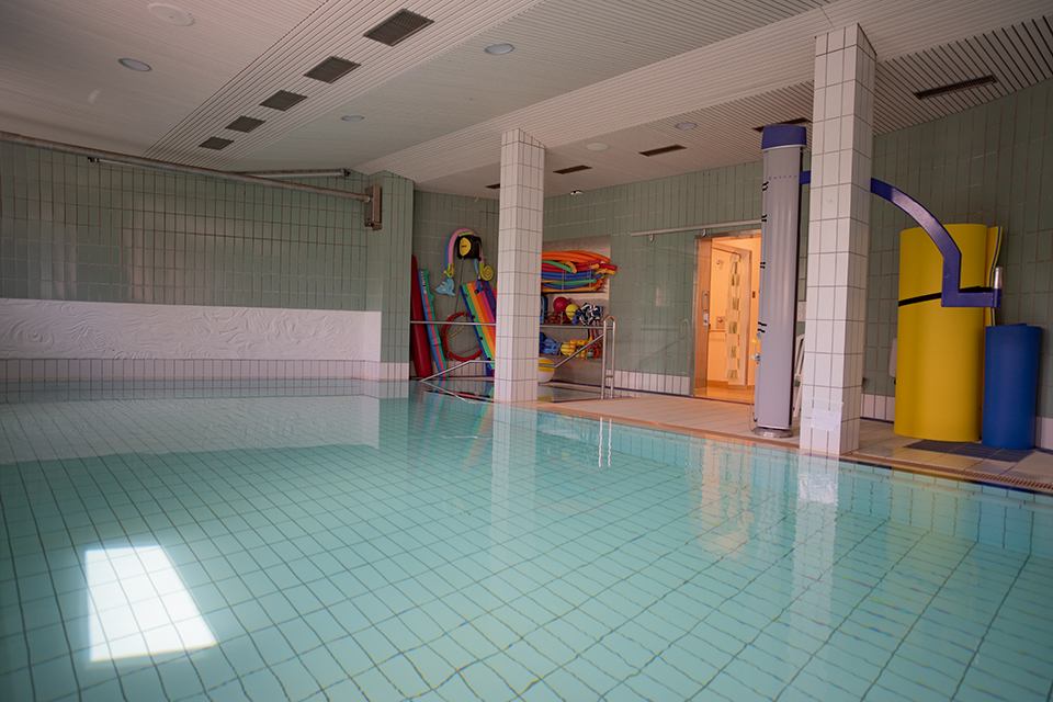 Das Bild zeigt ein Hallenbad mit leerem Pool.
