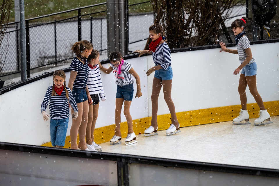 Das Bild zeigt sechst Mädchen beim Eiskunstlaufen.